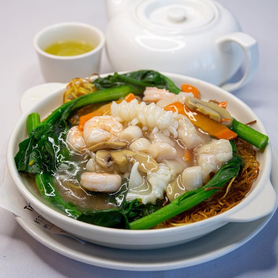 Diamond Palace's crispy noodles with seafood, mushrooms, and green vegetables in a savory sauce.